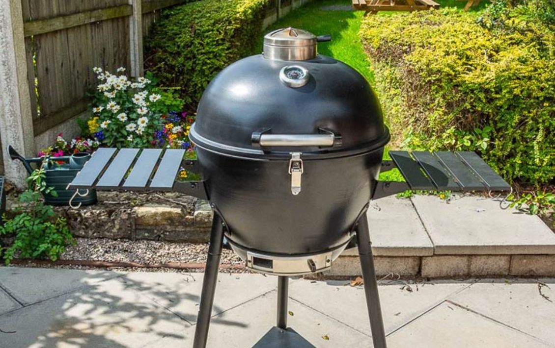 A Bar-Be-Quick 21-inch Steel Kamado barbecue with a lid and two shelves on a patio