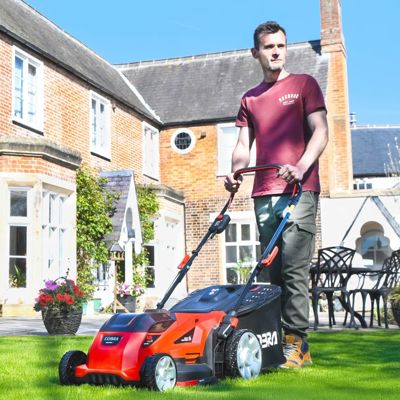 A man mowing a lawn with a Cobra lawn mower