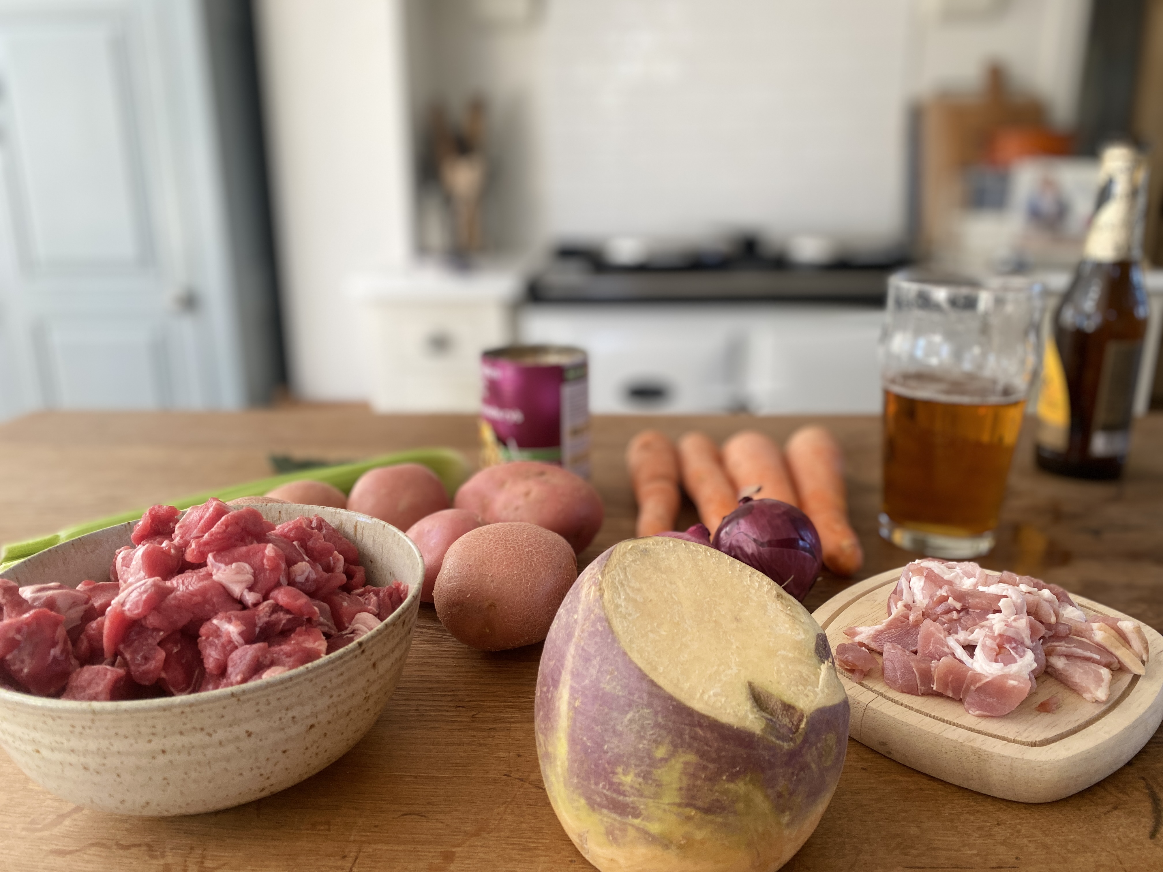 Ingredients for beef stew: beef, swede, carrots, leeks, potatoes, onions, bacon, beans and beer