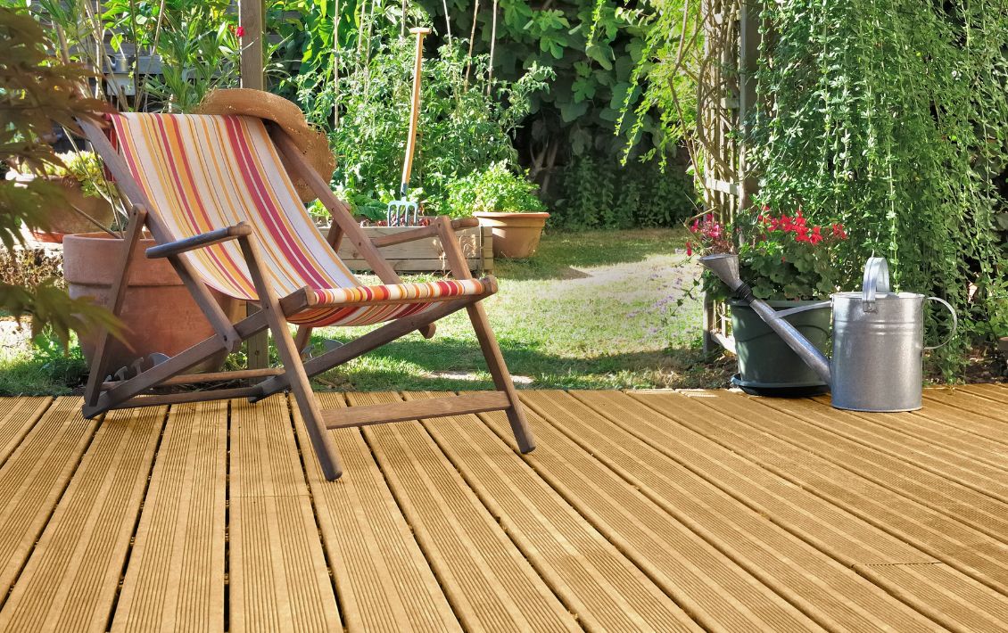 A deck chair on decking in a garden