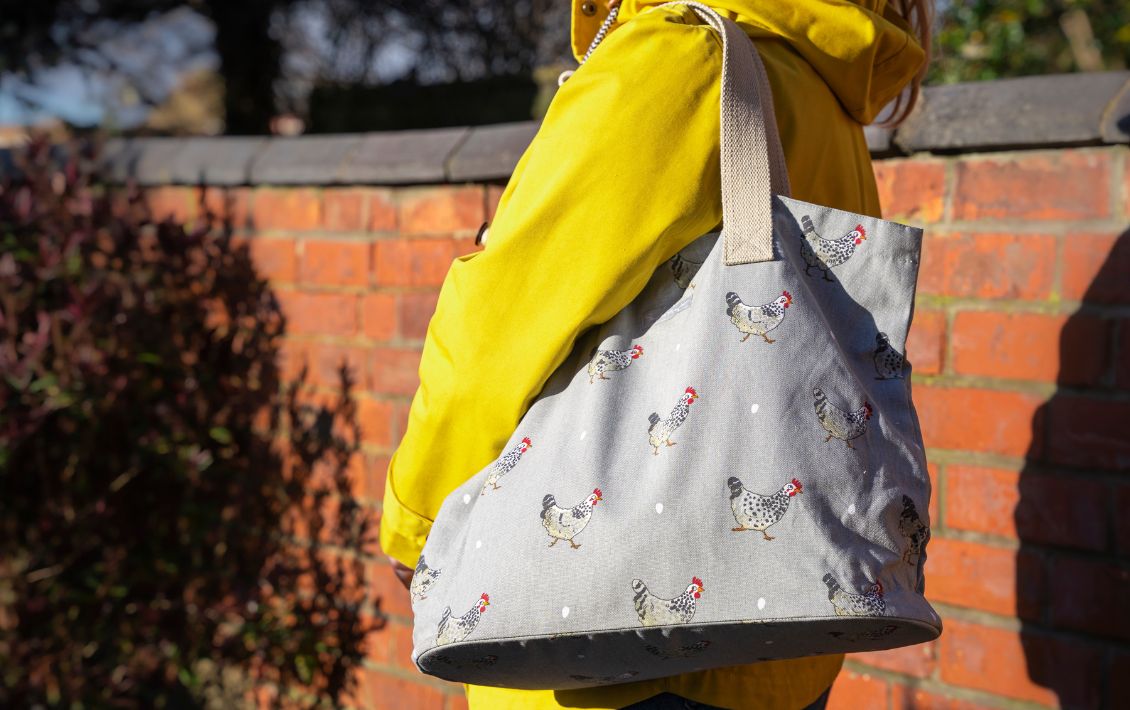 A lady in a yellow jacket with a Sophie Allport bag on her shoulder