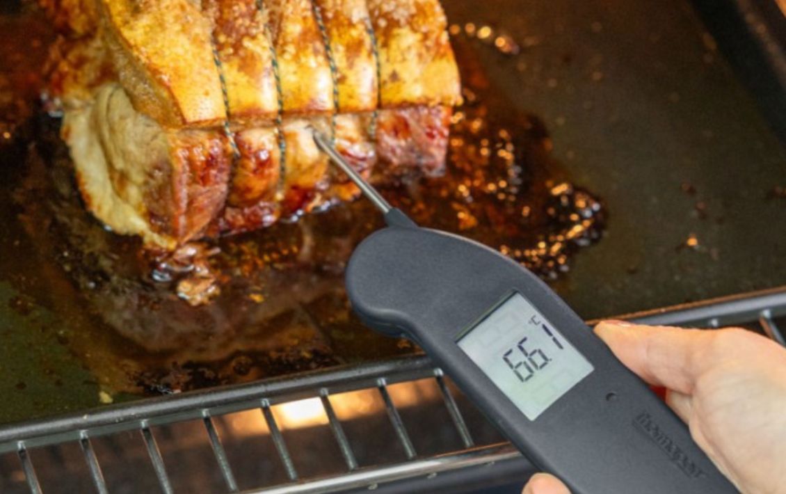 Someone testing the temperature of a roasted joint of meat with a meat thermometer from Butchers Sundries  