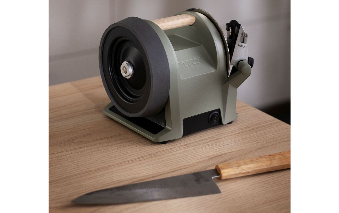 Tormek knife sharpener in Ash Green and a knife on a kitchen table 