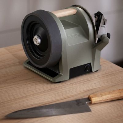 Tormek knife sharpener in Ash Green and a knife on a kitchen table 