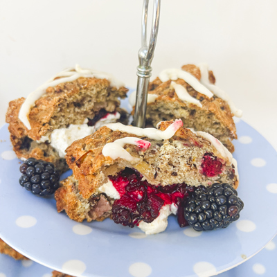 Scones with cream and blackberries on a blue and white polka dot plate