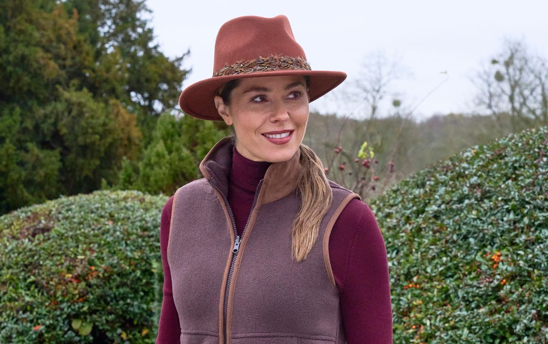 A lady in the countryside wearing a bark coloured Alan Paine gilet  