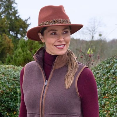 A lady in the countryside wearing a bark coloured Alan Paine gilet  