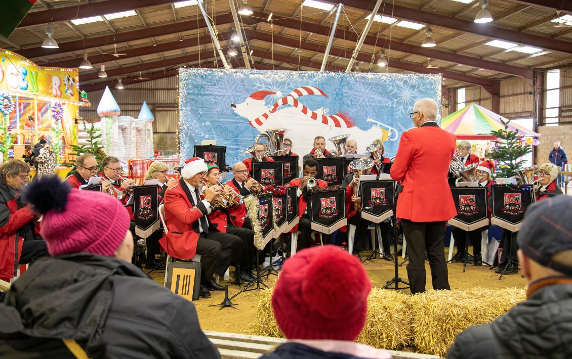 A brass band playing at a rural Christmas event in an outdoor building