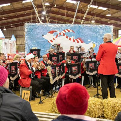 A brass band playing at a rural Christmas event in an outdoor building