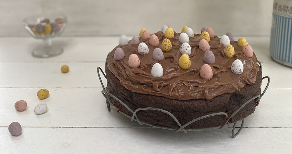 A photo of a rich and gooey chocolate  Easter egg cake on a white countertop