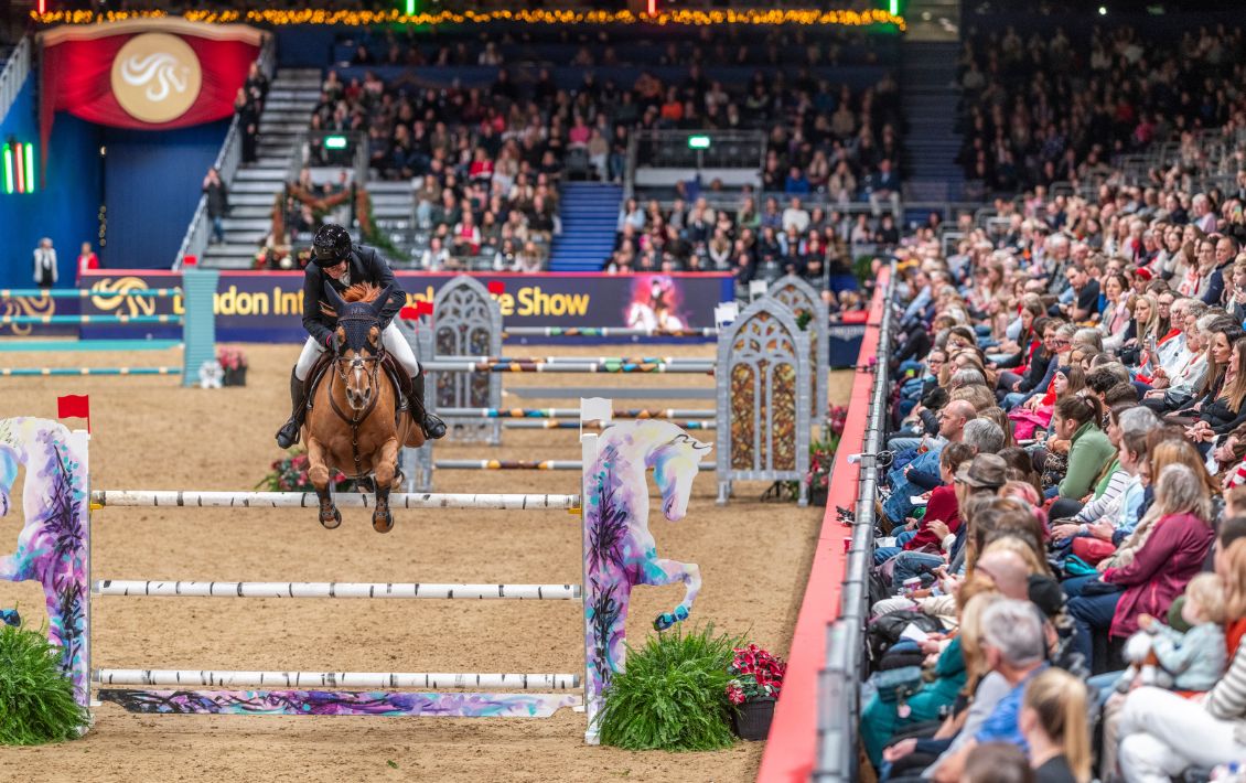 A horse and rider jumping a fence at the London International Horse Show